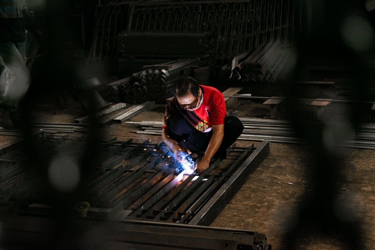 Fabricator welding a custom steel gate frame in a Navi Mumbai workshop